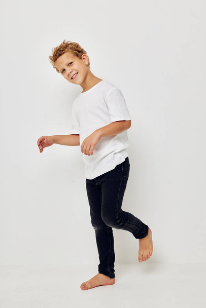 boy in a white t-shirt barefoot in full growth - Фото, изображение