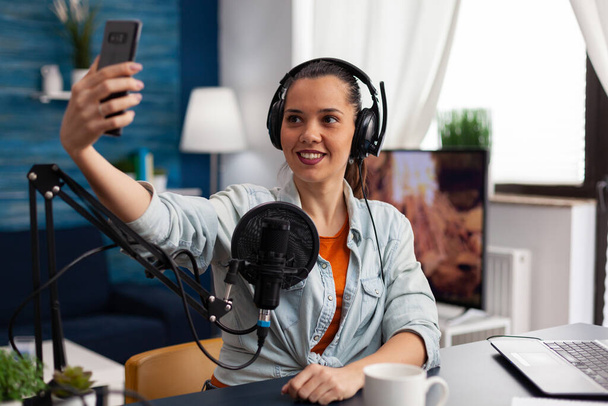 Woman content creator using headphones and microphone - Foto, immagini