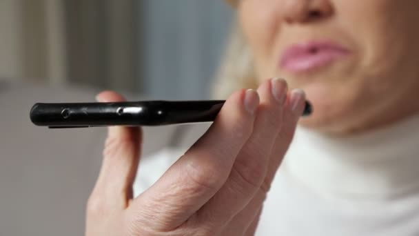 Middle aged woman talks via smartphone using loudspeaker - Footage, Video