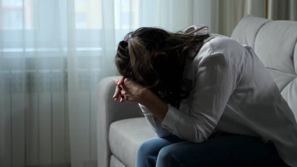 Депрессивная женщина-инвалид чувствует себя плохо, сидя дома на диване - Кадры, видео