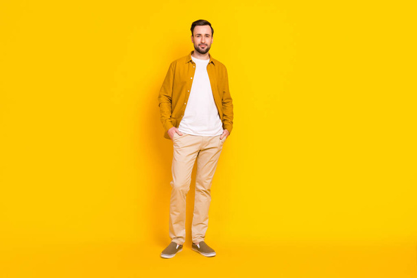 Full length photo of pretty sweet young gentleman dressed casual outfit standing arms pockets isolated yellow color background. - Zdjęcie, obraz