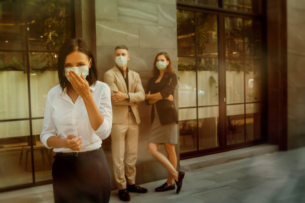 Une jeune femme qui tousse à cause de la grippe ou qui est allergique à la poussière porte un masque médical pour se protéger et protéger son entourage pour la sécurité publique.. - Photo, image