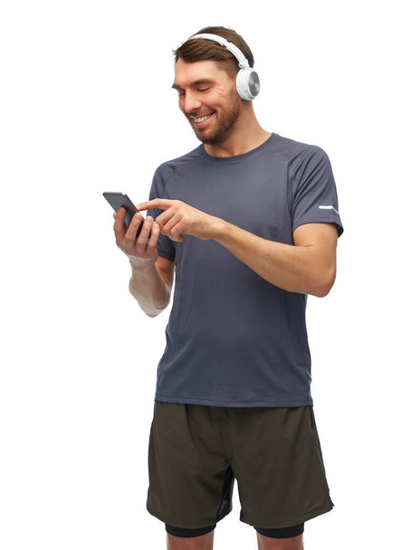 man in sports clothes with phone and headphones - Фото, изображение