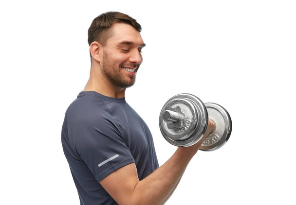 happy smiling man exercising with dumbbells - Фото, изображение