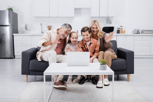 cheerful kids with grandparents waving hands during video call on laptop - Photo, Image