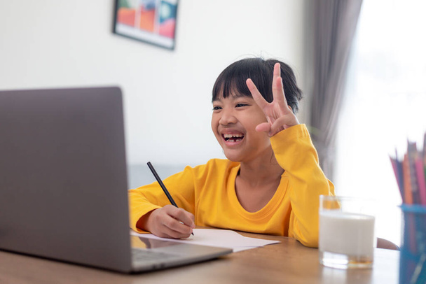 Asian girl student online learning class study online video call zoom teacher, Happy girl learn english language online with laptop at home.New normal.Covid-19 coronavirus.Social distancing.stay home - Fotoğraf, Görsel