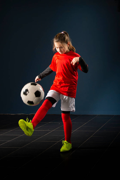 An elementary school girl is playing indoor soccer - Φωτογραφία, εικόνα
