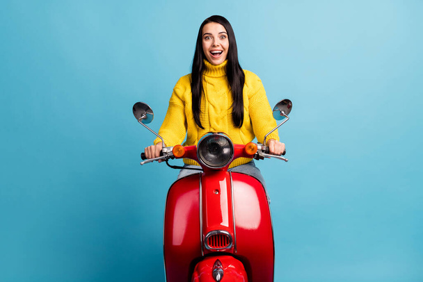 Photo of excited crazy brunette lady drive motorbike open mouth wear yellow sweater isolated blue background. - Photo, Image