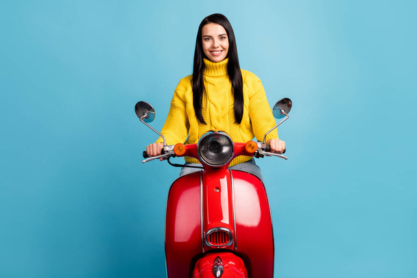 Photo portrait of cheerful girl sitting on red retro scooter smiling isolated on vivid blue color background. - Photo, Image