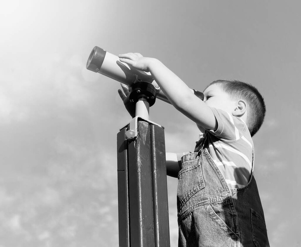 Мальчик смотрит в игрушечный телескоп. Explorer. - Фото, изображение