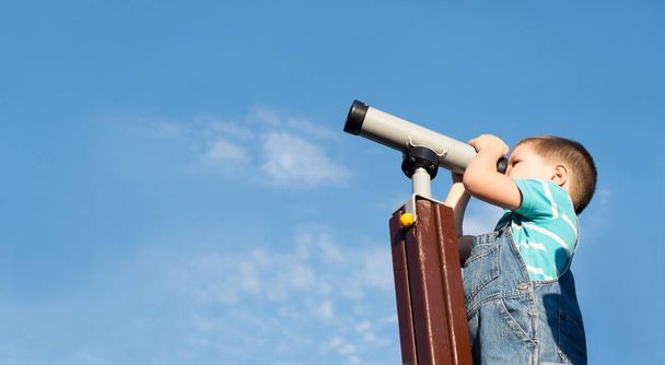 Boy looking through a toy telescope. Explore. - Φωτογραφία, εικόνα