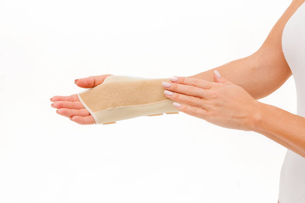 Halter für eine schnelle Genesung und die Schmerzen im Handgelenk. Eine Handgelenkspange ist ein Kleidungsstück, das um das Handgelenk getragen wird, um es bei starkem Gebrauch zu schützen oder zu heilen.. - Foto, Bild