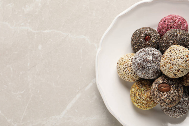 Different delicious vegan candy balls on light grey marble table, top view. Space for text - Fotografie, Obrázek