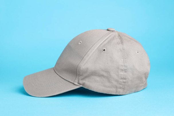 Stylish grey baseball cap on light blue background - Valokuva, kuva