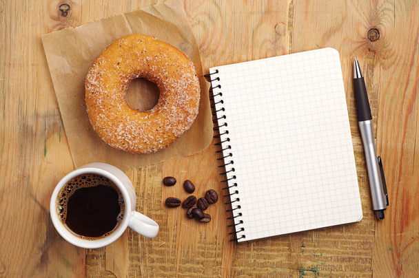 notebook en koffie met donut - Foto, afbeelding