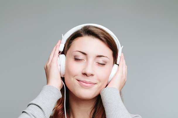 Młoda kobieta ze słuchawkami - Zdjęcie, obraz