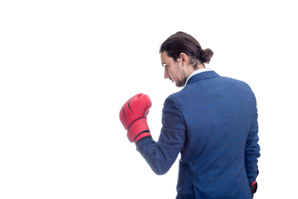 Бизнесмен в красных боксерских перчатках стоит в боевой позиции. Портрет решительного делового человека, подготовленный к бою изолирован на белом фоне. Концепция самообороны сотрудников - Фото, изображение