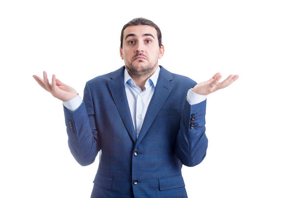 Clueless and perplexed businessman shrugging shoulders, hands outstretched, has doubts. Puzzled business person spreads his arms expressing uncertainty isolated on white background - Photo, Image