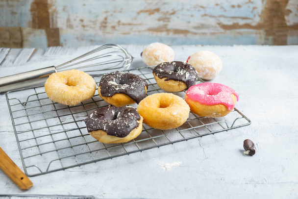 Chocolate donuts and pink donuts on the kitchen table - Foto, immagini