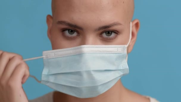 Kel Saçlı Kadın Mavi Arkaplan Üzerinde Koruyucu Yüz Maskesini Çıkartıyor - Video, Çekim