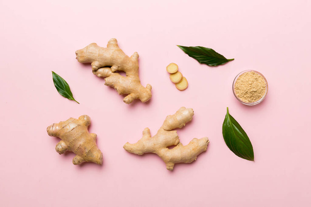 Finely dry Ginger powder in bowl with green leaves isolated on colored background. top view flat lay. - Foto, immagini