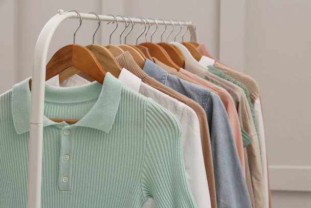 Rack with stylish clothes near light wall - Foto, imagen
