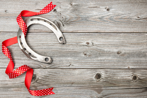 Horseshoe with red ribbon on old wooden - Foto, Imagem