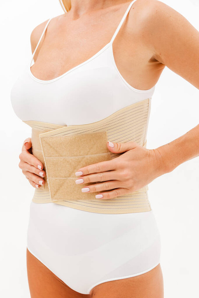 Orthopedic lumbar corset on the human body. Back brace, waist support belt for back. Posture Corrector For Back Clavicle Spine. Post-operative Hernia Pregnant and Postnatal Lumbar brace after surgery. - Photo, Image