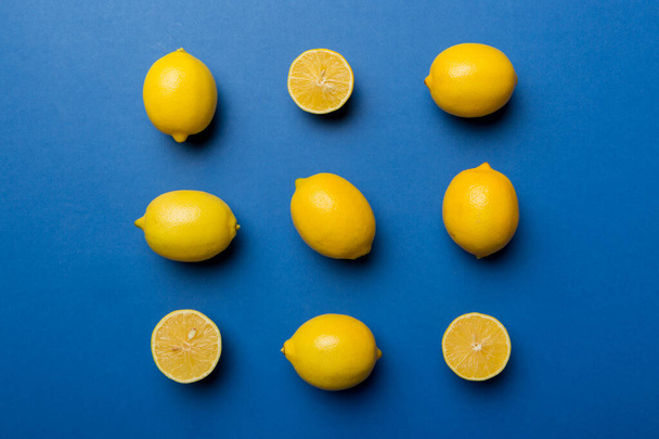 Many fresh ripe lemons as colored background, top view. Elegant background of lemon and lemon slices Top view flat lay. - Foto, immagini