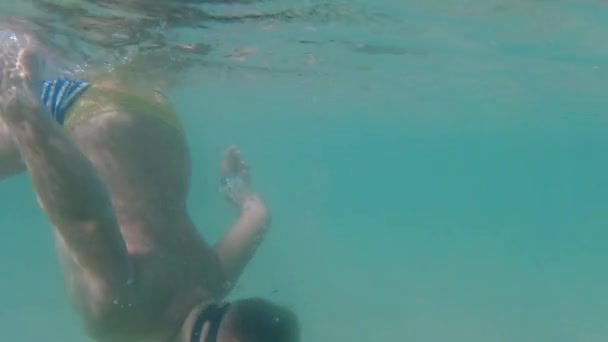 A child in an underwater mask learns to swim and dive. The boy dives into the sea. - Záběry, video