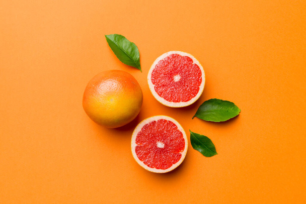 fresh Fruit grapefruit with Juicy grapefruit slices on colored background. Top view. Copy Space. creative summer concept. Half of citrus in minimal flat lay with copy space. - Photo, Image