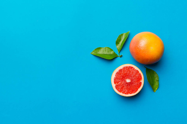 fresh Fruit grapefruit with Juicy grapefruit slices on colored background. Top view. Copy Space. creative summer concept. Half of citrus in minimal flat lay with copy space. - Φωτογραφία, εικόνα