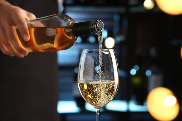 Bartender pouring white wine into glass indoors, closeup - Foto, Bild