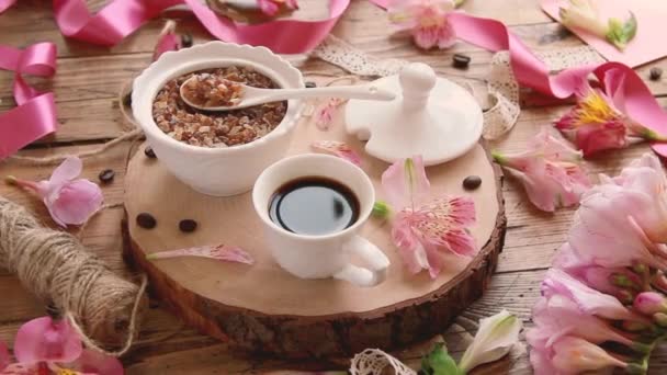 šálek kávy na dřevěném stole a květiny - Záběry, video