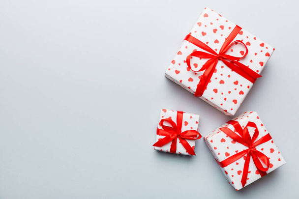 Ystävänpäivä koostumus: punainen lahjapakkaus, jossa on keula ja sydän. Joululahja. Näkymä ylhäältä. Tekstiavaruus. Holday onnittelukortti. - Valokuva, kuva