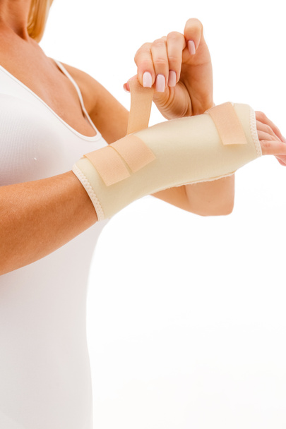 Retentor para uma rápida recuperação e a dor no pulso. Uma cinta de pulso é uma peça de vestuário que é usada ao redor do pulso para protegê-lo durante o uso forte ou para permitir que ele se cure.. - Foto, Imagem