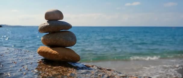 Πυραμίδα από πέτρες στην παραλία. Η έννοια της αρμονίας και της χαλάρωσης . - Πλάνα, βίντεο