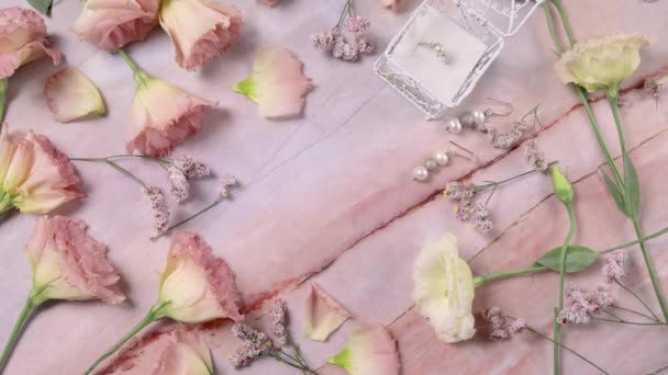 Mano mette la carta AMORE su un tavolo di marmo vicino a fiori rosa da vicino - Filmati, video