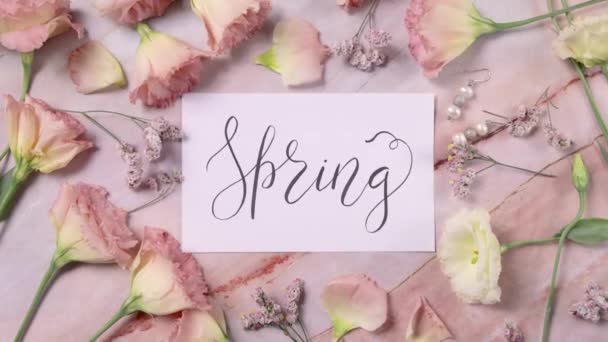SPRING kártya egy márvány asztal közelében rózsaszín virágok felső nézet nagyítás - Felvétel, videó