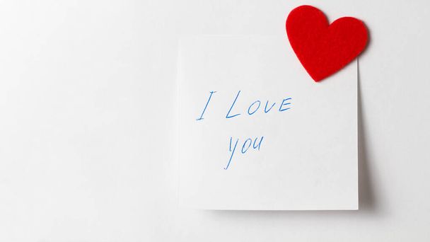 A close up of a white sticky note with the word I Love You with red heart. Valentine's Day. Valentine's Day background. I love you lettering text. love concept. - Fotografie, Obrázek