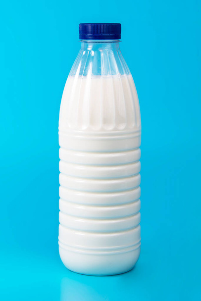 Garrafa de leite fresco natural no fundo azul fechar - Foto, Imagem