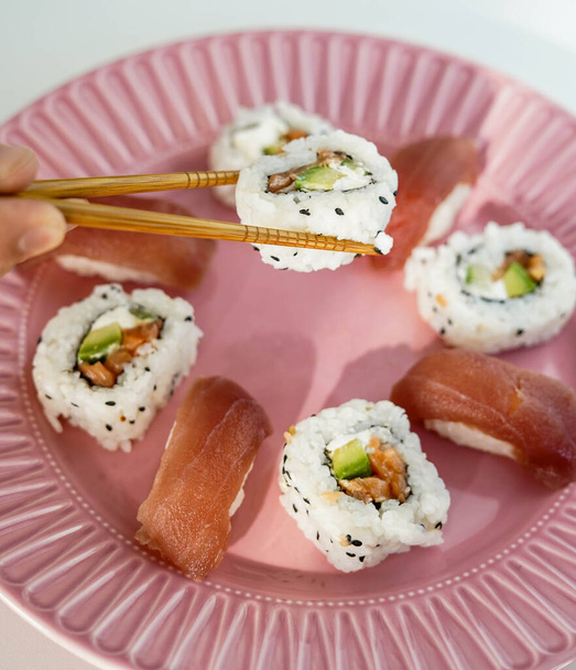 Una bandeja con varios trozos de sushi. Rollo de California. - Foto, Imagen