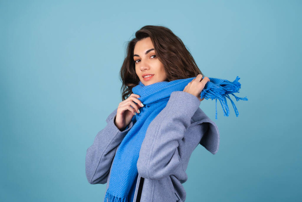 Spring autumn portrait of a woman in a blue knitted sweater, scarf and gray coat, posing cheerfully, smiling, in anticipation of spring - Foto, afbeelding