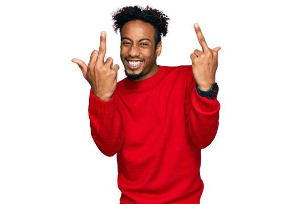 Young african american man with beard wearing casual winter sweater showing middle finger doing fuck you bad expression, provocation and rude attitude. screaming excited  - Valokuva, kuva