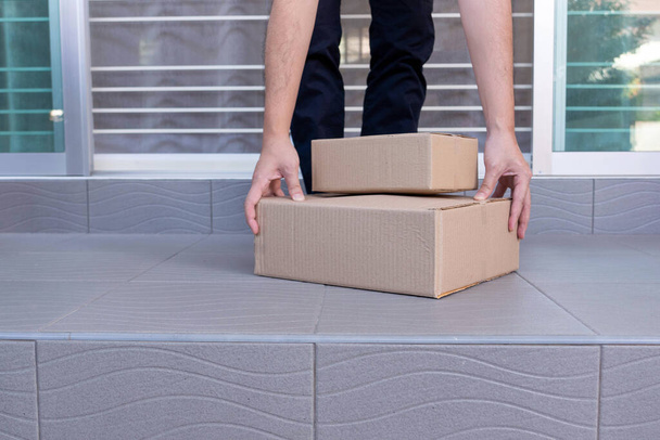 E-commerce concept een man die het huis verlaat en de dozen optilt om ze via tracking express naar zijn klanten te sturen. - Foto, afbeelding