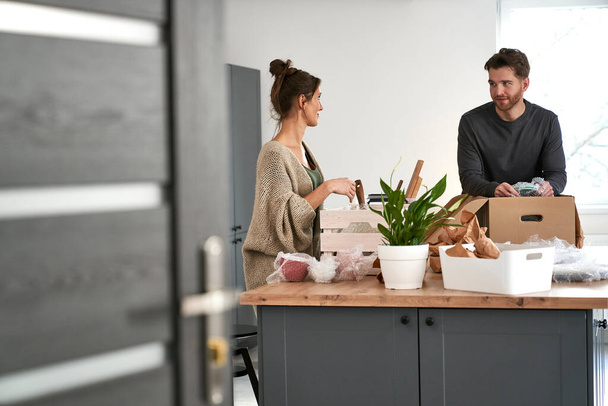 Caucasian couple chatting and packing some kitchen stuff - Foto, afbeelding
