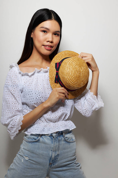 pretty brunette in white shirts hat fashion posing light background unaltered - Foto, afbeelding