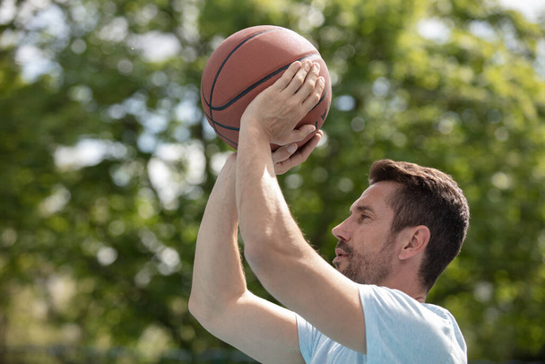 basketball player makes a throw on outdoor court - Fotografie, Obrázek