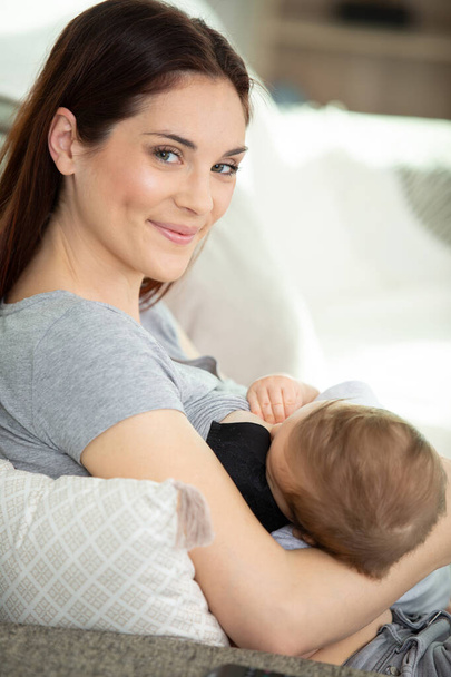 young mother feeding breast her baby at home - Foto, Bild