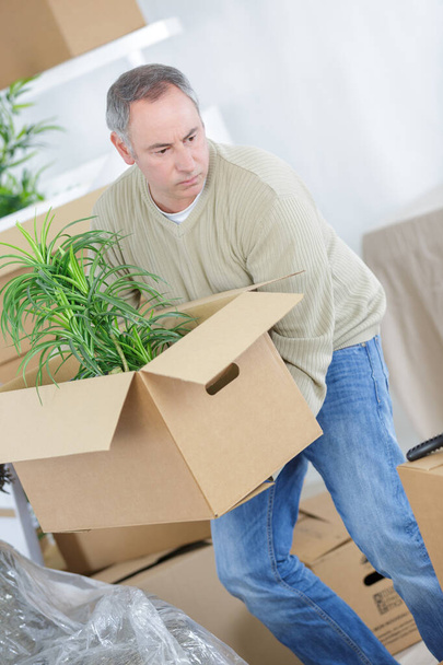 middle-age man moving boxes at home - Foto, Imagem
